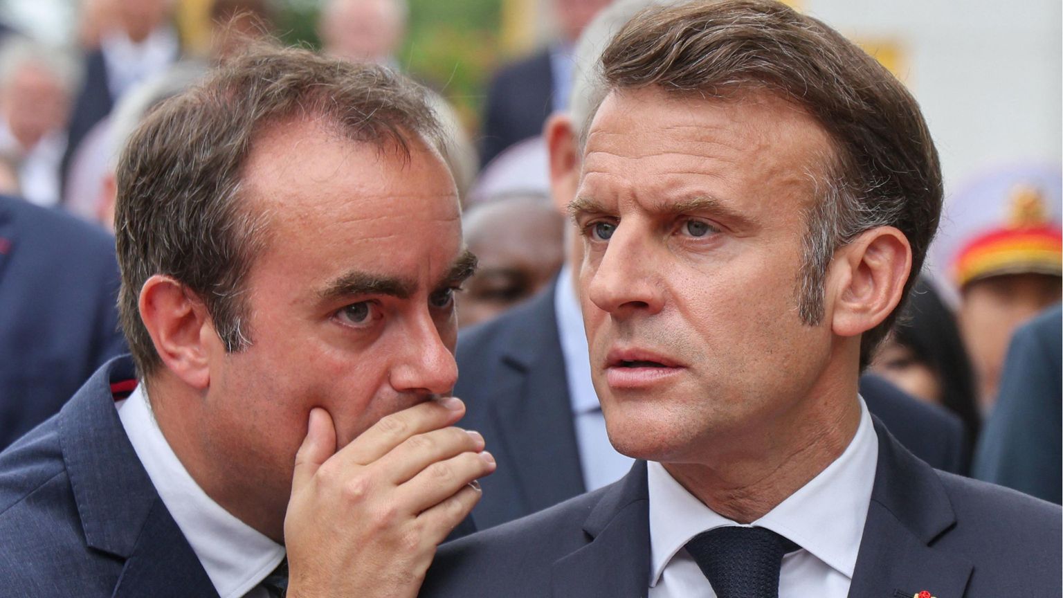 Lecornu sussurra all'orecchio di Macron, che lo ascolta con fronte corrugata