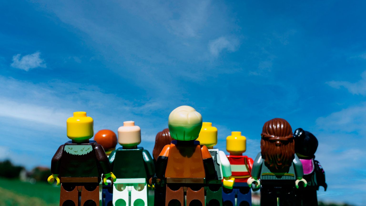 Nove omini Lego si muovono su un prato e guardano un cielo che diventa sempre più blu