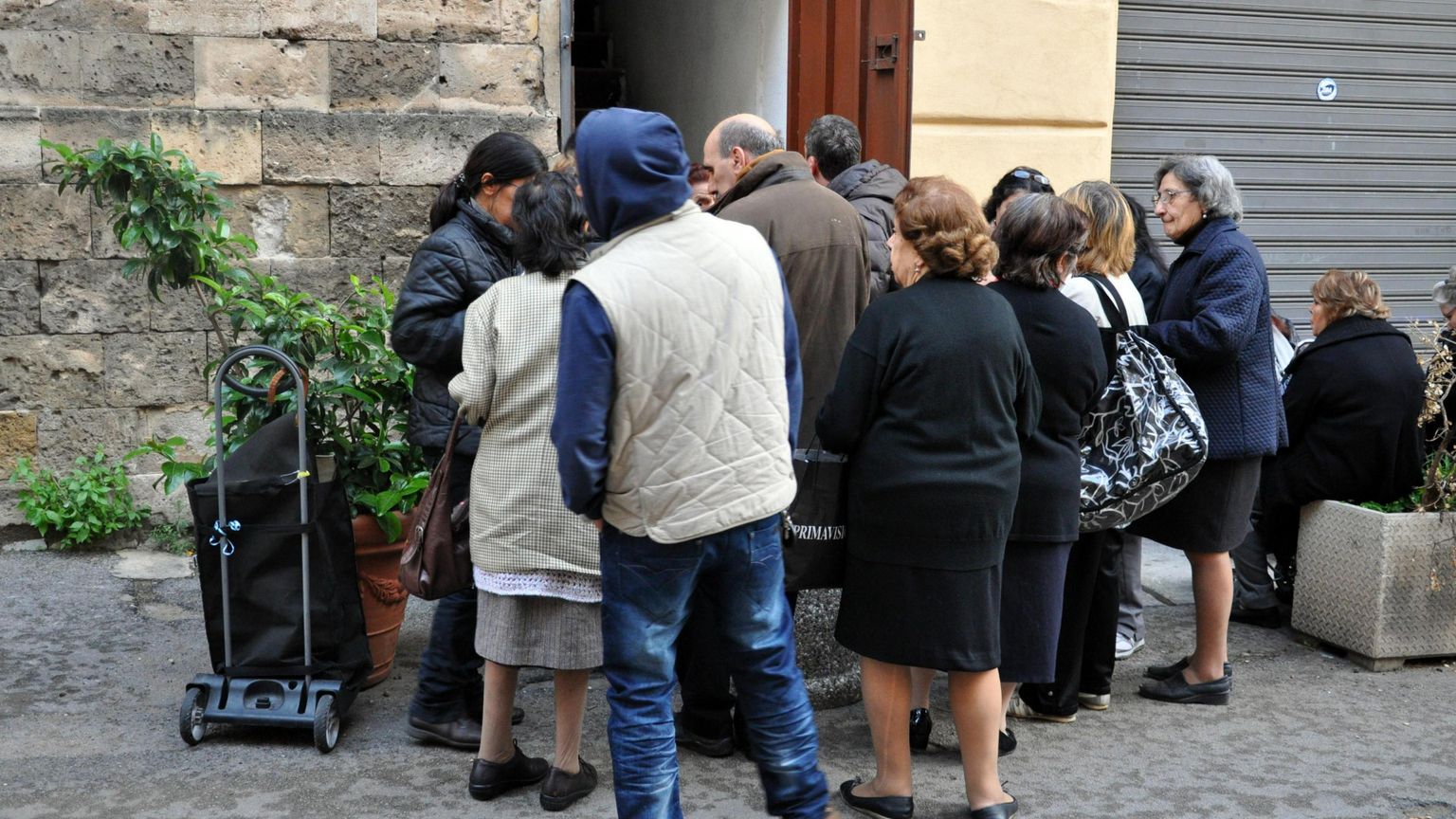 Famiglie povere mangiano a una mensa della Caritas