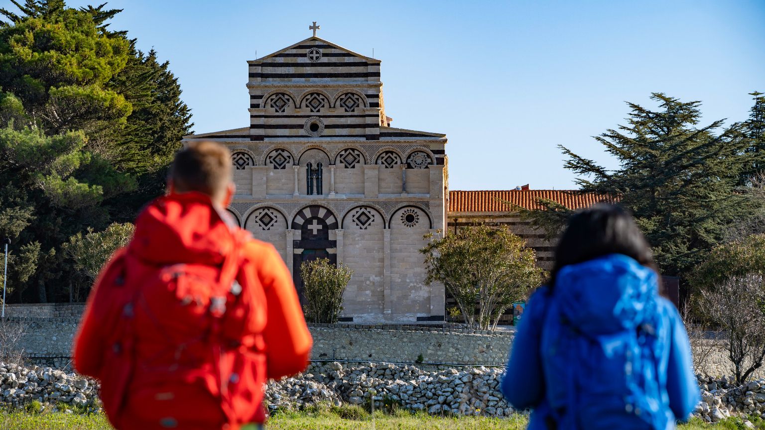 Due camminatori, zaino in spalla, si dirigono verso il Monastero di San Pietro di Sorres a Borutta