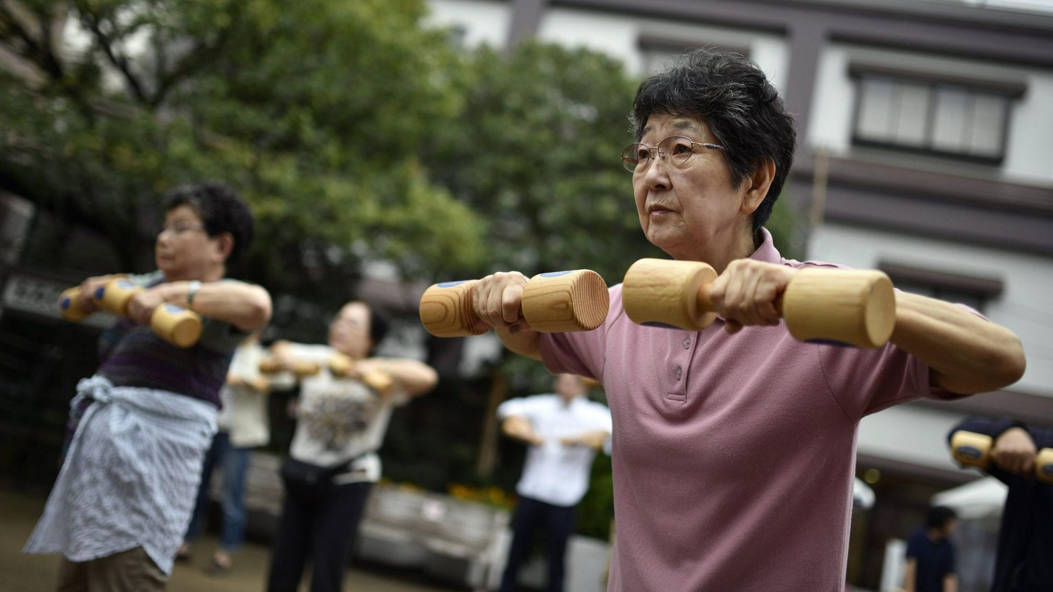 Anziani fanno ginnastica in un parco pubblico a Tokyo