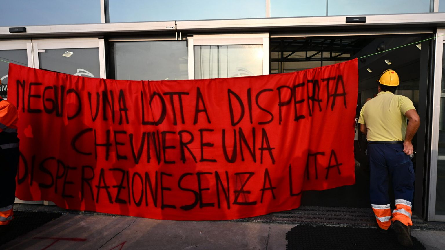 Un operaio con uno striscione protesta per la sicurezza sul lavoro