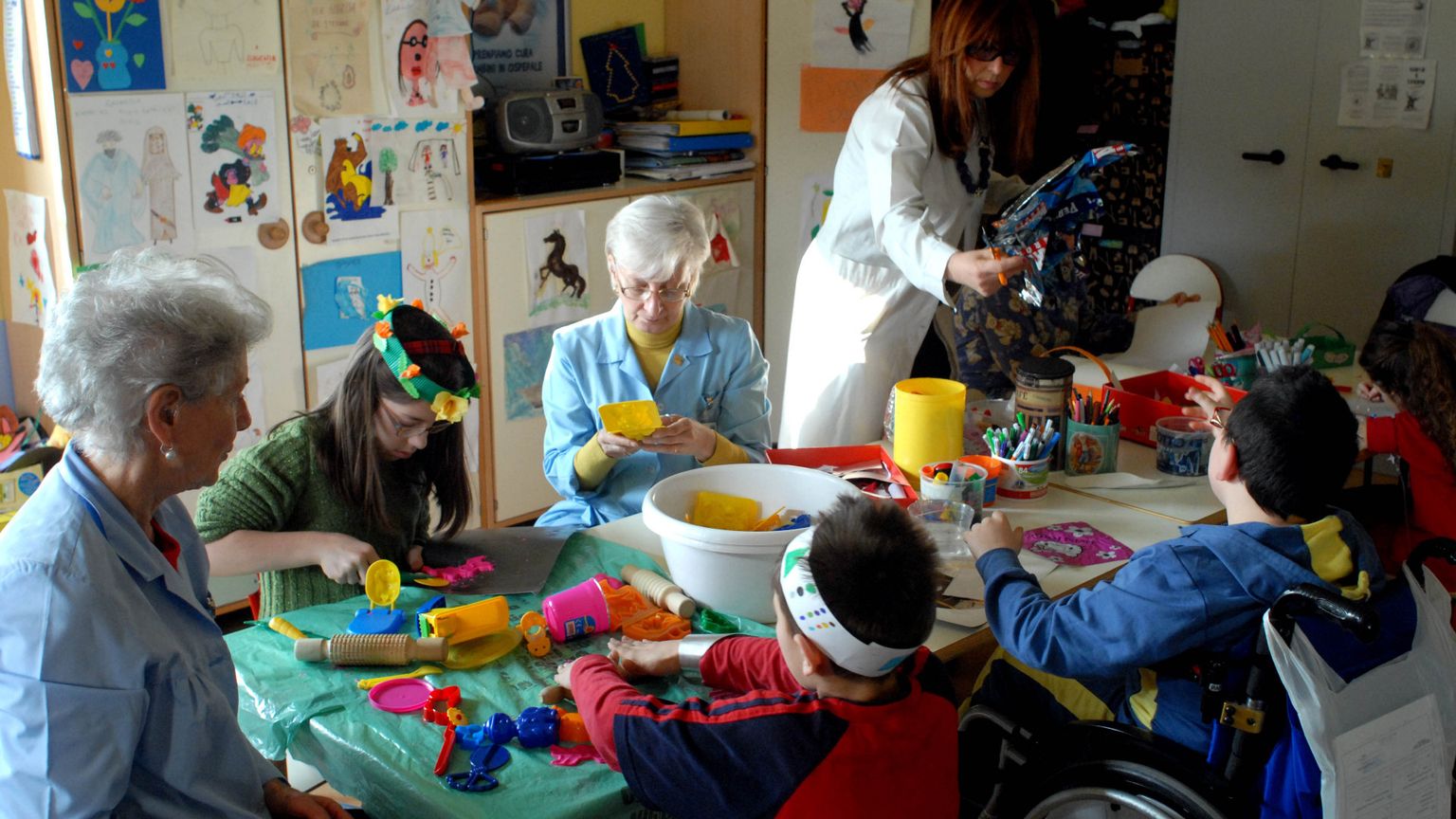 Anziane volontarie al lavoro con i bambini in un ospedale