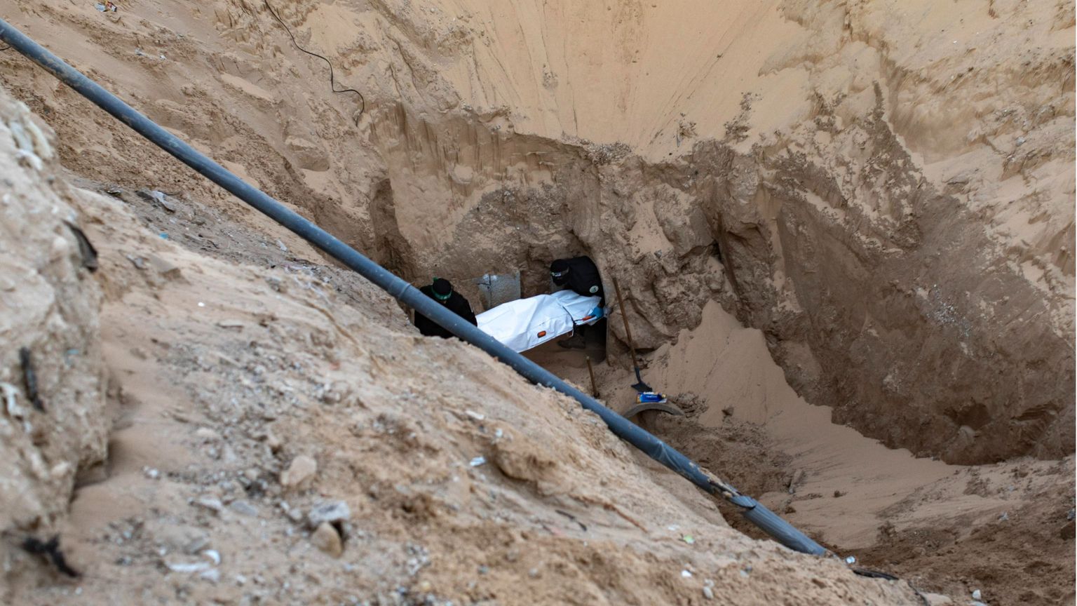 Miliziani di Hamas seppelliscono il corpo di un israeliano dopo averlo recuperato da un tunnel in Khan Yunis, nel sud di Gaza