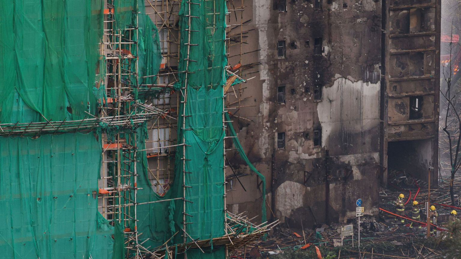 Quel che resta delle impalcature di bambù sui grattacieli bruciati a Hong Kong