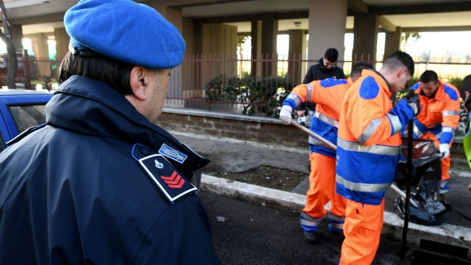 Detenuti impegnati in lavori socialmente a Roma sotto lo sguardo di un agente penitenziario