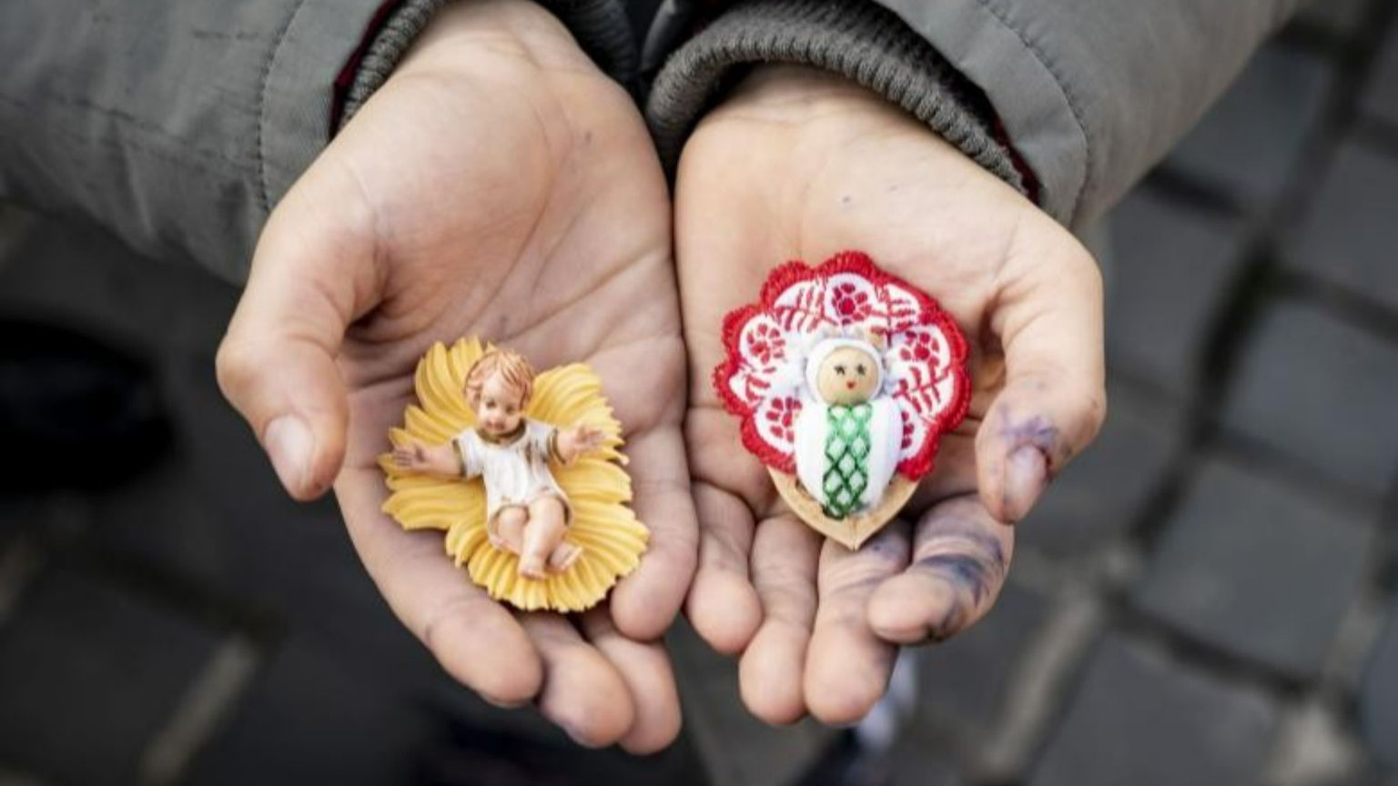 Le statuine di Gesù bambino in mano a un ragazzino in piazza San Pietro