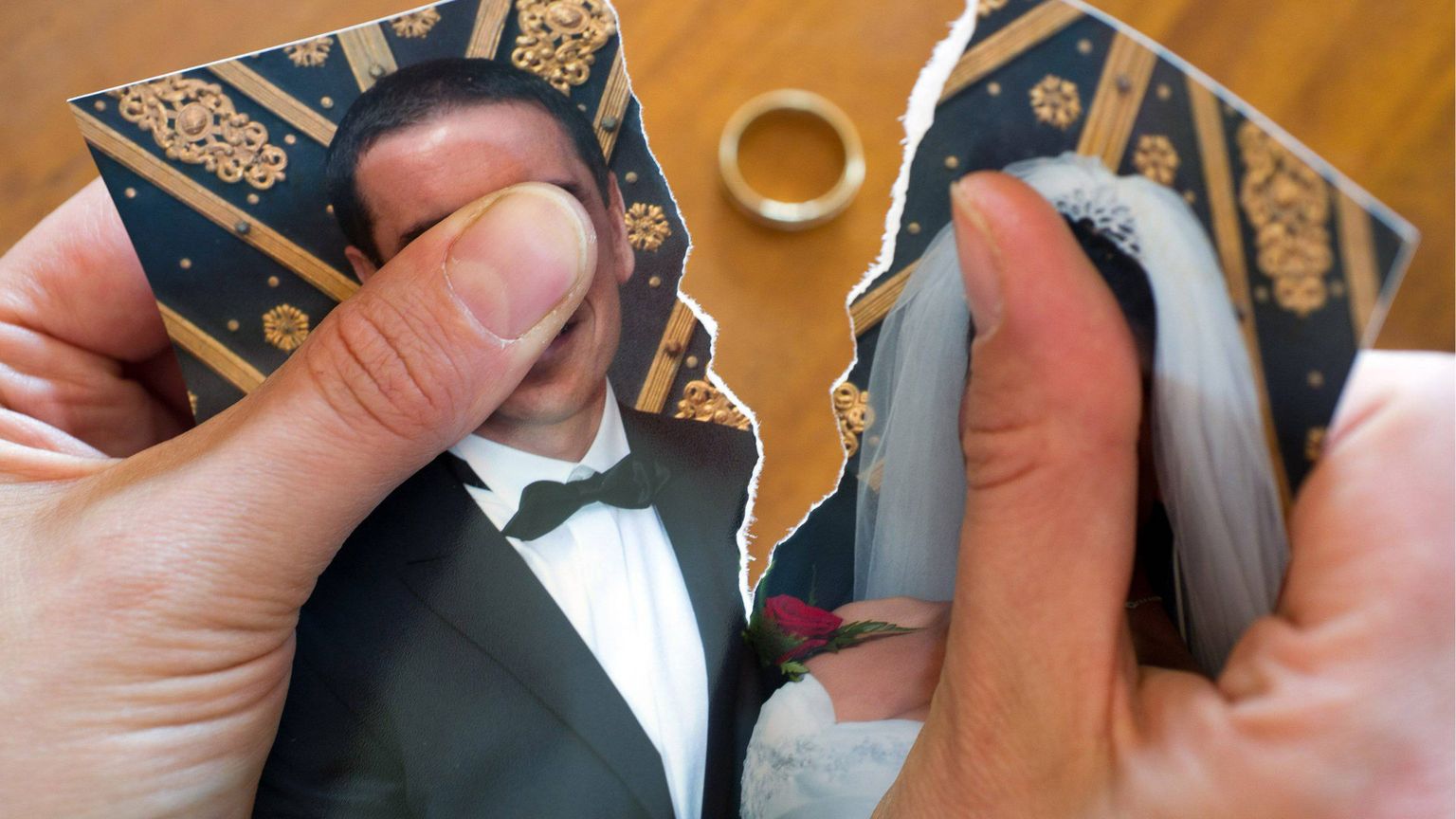 Una foto di due sposi spezzata in due con una fede nuziale al centro