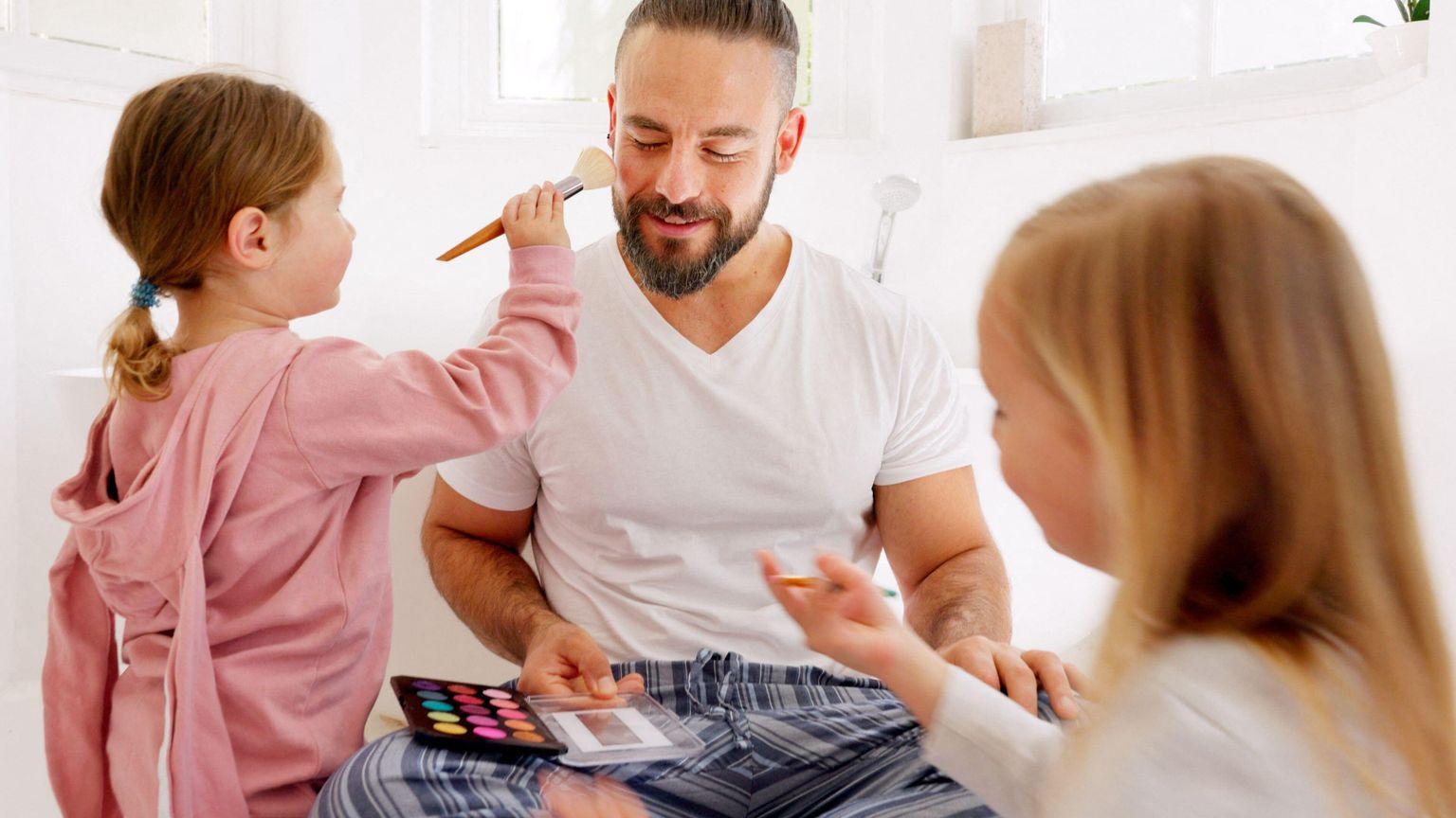 Due bimbe truccano il loro papà