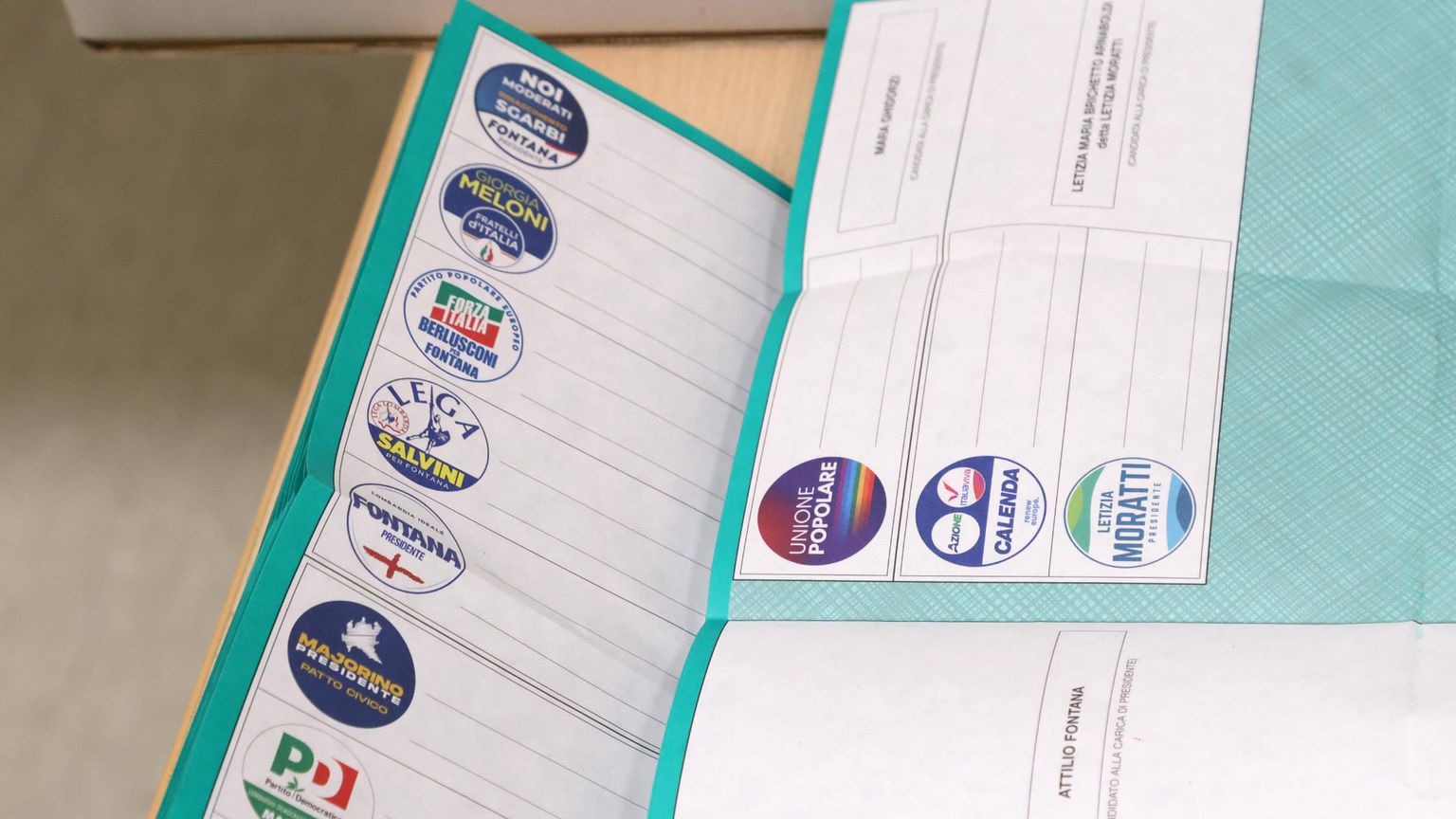 Schede elettorali aperte verdi con i simboli dei vari partiti