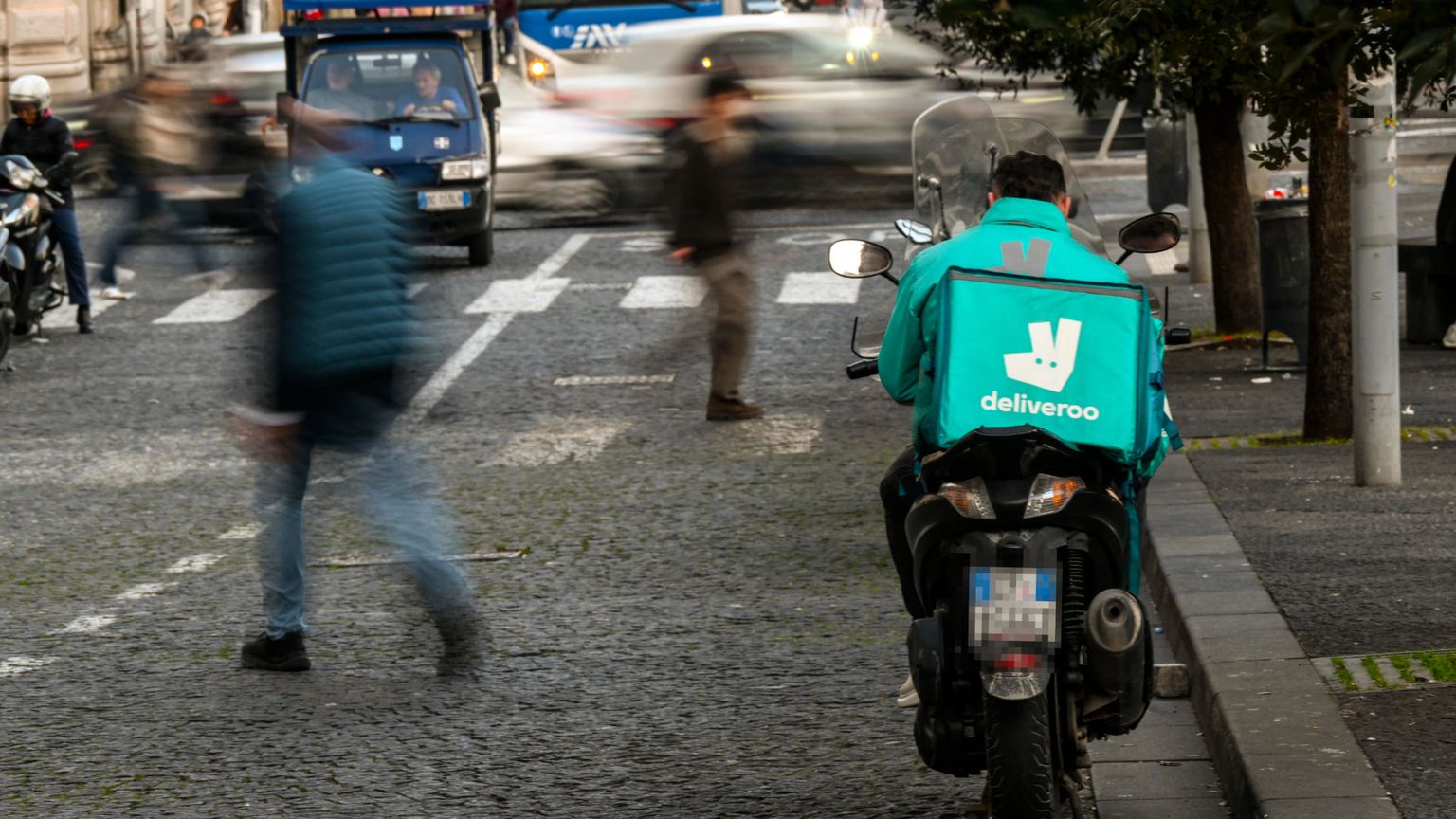Un rider Deliveroo in attesa di chiamata a Napoli / Ansa