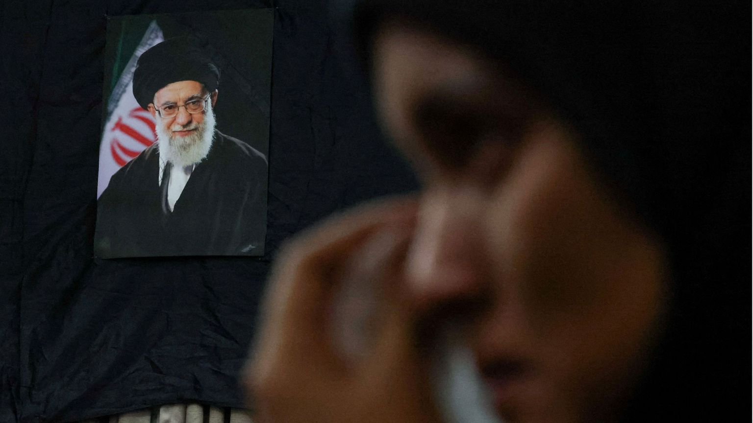Una donna piange davanti alla foto dell'ayatollah Khamenei