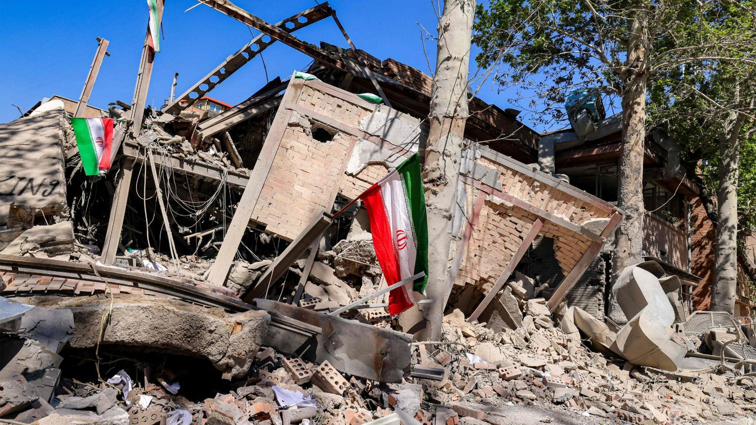 Le bandiere dell'Iran sventolano sulle macerie