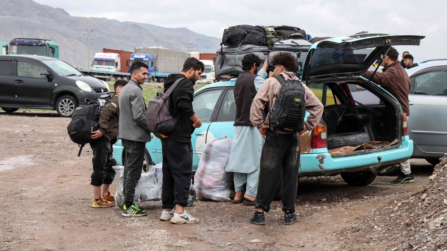 Migranti afghani radunati accanto a un veicolo pronti a tornare nelle proprie case vicino al confine tra Afghanistan e Iran, nel distretto di Zendeh Jan a Herat