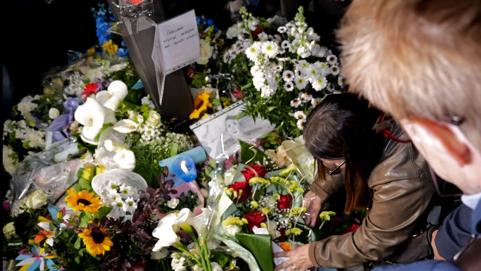 La mamma di Giacomo Bongiorni mentre depone dei fiori in memoria del figlio ucciso