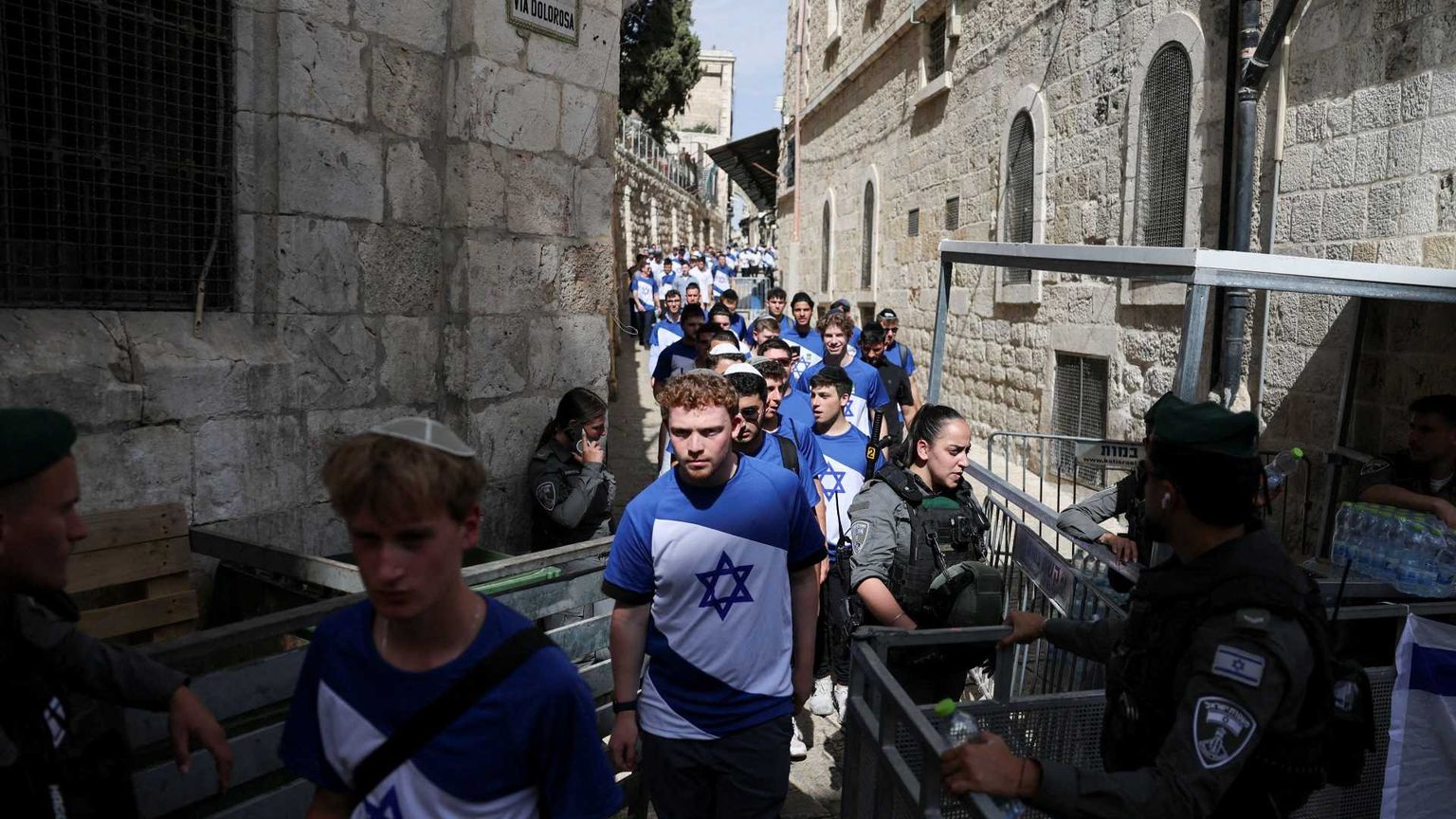 In un vicolo stretto della Città Vecchia una lunga fila di giovani che indossano magliette con la bandiera di Israele, bianche e celesti con la Stella di David, passano attraverso un controllo di polizia