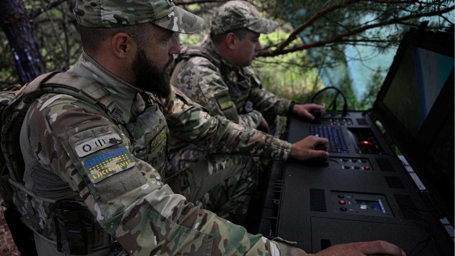 Due uomini in uniforme mimetica nel bosco