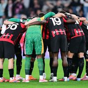 Giocatori del Milan in maglia rosonera radunati a centrocampo prima della partita