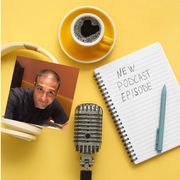 Cuffie, microfono e un quaderno sono pronti per la registrazione di un nuovo episodio di un podcast, accompagnati da una tazza di caffè