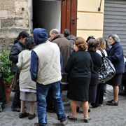 Famiglie povere mangiano a una mensa della Caritas