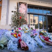 Nell'immagine sono visibili decine di mazzi di fiori lasciati davanti all'ingresso della Facoltà di Scienze della Sapienza di Roma per ricordare le donne vittime di femminicidio