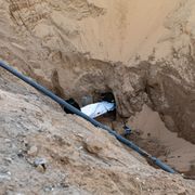 Miliziani di Hamas seppelliscono il corpo di un israeliano dopo averlo recuperato da un tunnel in Khan Yunis, nel sud di Gaza