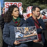 Una donna con un cartello che recita: "Non restiamo in silenzio davanti al massacro di alauiti, cristiani e drusi in Siria"