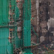 Quel che resta delle impalcature di bambù sui grattacieli bruciati a Hong Kong