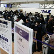 Passeggeri in fila all'Haneda Airport di Tokyo, dopo la cancellazione dei voli