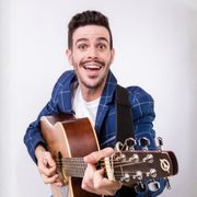 Lorenzo Baglioni, attore, ex-docente, conduttore televisivo, tiene in mano una radio rossa e nera, e sorride