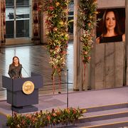 Sul palco del Premio Nobel per la Pace, agghindato di fiori, una giovane donna parla dal podio. Sullo sfondo, un grande ritratto dell'assente Machado