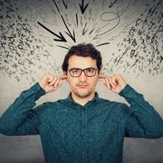 Un uomo si tappa le orecchie mentre tutto intorno volano parole