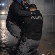Un agente di Polizia soccorso da un collega, durante gli scontri seguiti al corteo contro lo sgombero del centro sociale Askatasuna a Torino/ ANSA