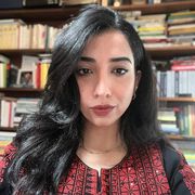 Il volto in primo piano di una giovane ragazza dagli occhi neri e i capelli neri lunghi e sciolti