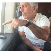 Il finanziere Jeffrey Epstein a bordo di un aereo indica qualcosa dal finestro. Al suo financo una donna il cui volto è stato oscurato per ragioni di riservatezza