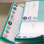 Schede elettorali aperte verdi con i simboli dei vari partiti