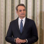 Un'immagine a mezzo busto di un uomo di mezza età in giacca e cravatta, capelli grigi, sguardo preoccupato