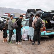 Migranti afghani radunati accanto a un veicolo pronti a tornare nelle proprie case vicino al confine tra Afghanistan e Iran, nel distretto di Zendeh Jan a Herat