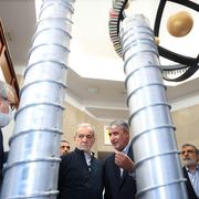 Un gruppo di funzionari iraniani e il presidente Massud Pezeshkian ispezionano dei grandi cilindri grigi in uno degli impianti del programma nucleare