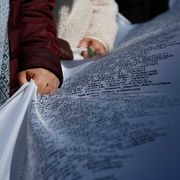 Un gruppo di volontari trasporta il sudario con i dati dei minori morti nella Striscia di Gaza