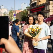 Studenti delle scuole superiori e le loro famiglie posano per le foto dopo aver sostenuto il Gaokao a Pechino nel 2025