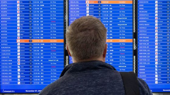 Un passeggero guarda il tabellone dove i voli Usa stanno ritornando regolari. Lo shutdown ha gettato nel caos il traffico aereo americano