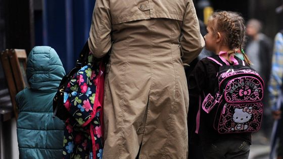 Una famiglia inglese, con due bambine, all'ingresso della scuola