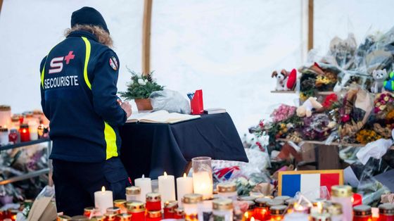 Un soccorritore lascia un messaggio sul libro del memoriale delle vittime: nel rogo di Capodanno sono morte 40 persone e altre 116 sono rimaste ferite / AFP