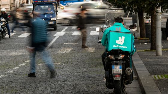 Un rider Deliveroo in attesa di chiamata a Napoli / Ansa