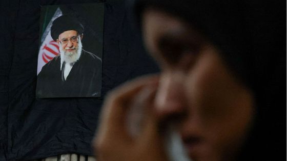 Una donna piange davanti alla foto dell'ayatollah Khamenei