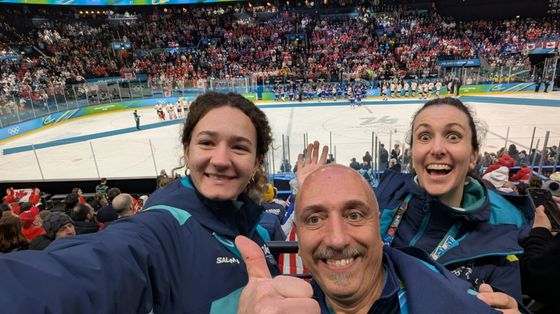 Luca Graziano all'Arena Santa Giulia con altre due volontarie durante le Olimpiadi Milano-Cortina