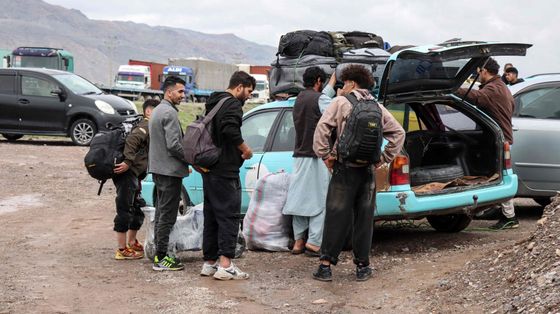 Migranti afghani radunati accanto a un veicolo pronti a tornare nelle proprie case vicino al confine tra Afghanistan e Iran, nel distretto di Zendeh Jan a Herat