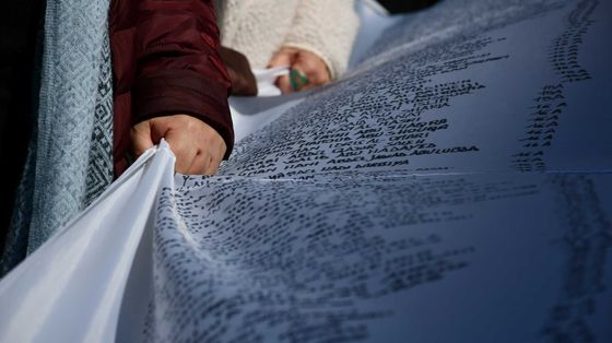 Un gruppo di volontari trasporta il sudario con i dati dei minori morti nella Striscia di Gaza
