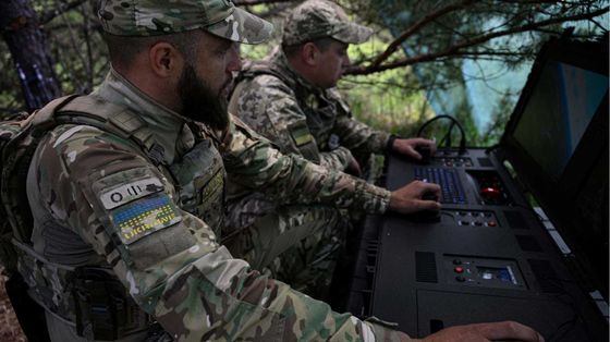 Due uomini in uniforme mimetica nel bosco